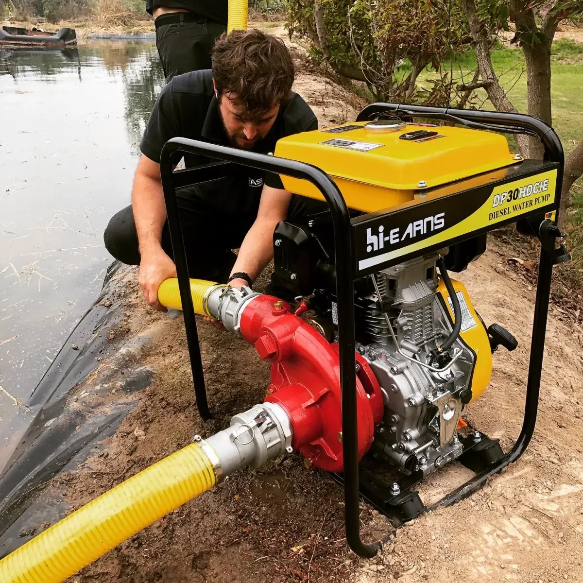 Técnico de Rasa Motores conectando una motobomba diesel Hi-Earns DP30HDCIE a la orilla de un tranque de riego